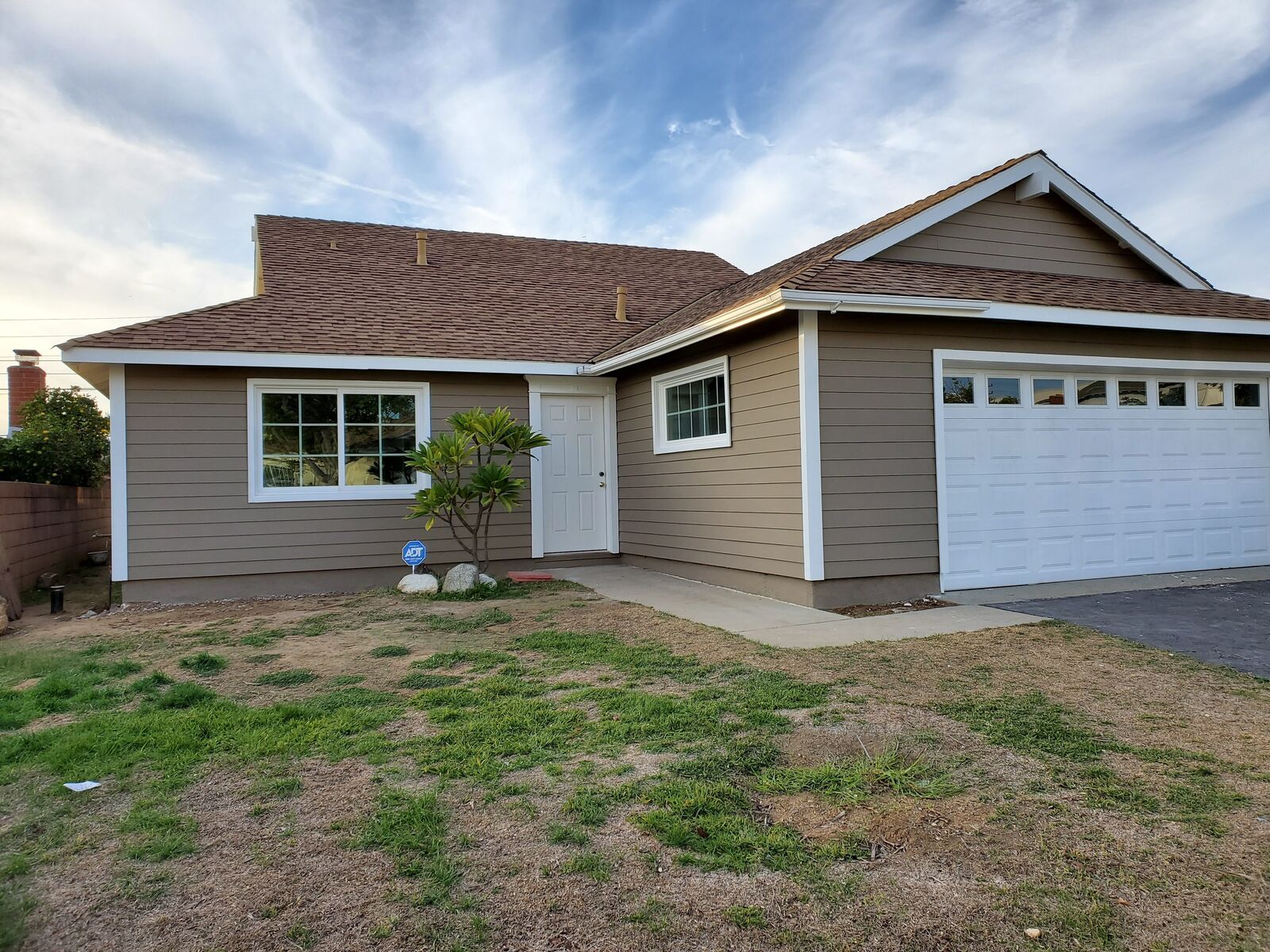 Completed exterior repaint — tan siding with crisp white trim
